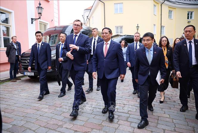 Thủ tướng Phạm Minh Chính và Thủ tướng Estonia Kristen Michal đi bộ trong khu phố cổ Tallinn. Ảnh: Dương Giang-TTXVN 

