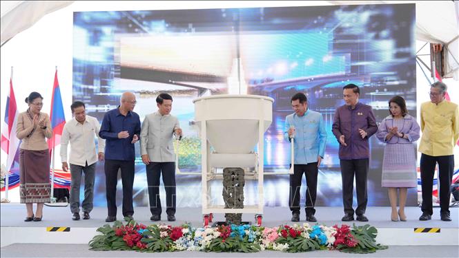 Phó Thủ tướng hai nước Lào-Thái Lan và đại diện các bộ, ngành hai nước thực hiện nghi thức đổ bê tông hợp long cầu. Ảnh: Xuân Tú - PV TTXVN tại Lào