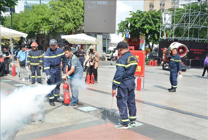 Các bạn trẻ được hướng dẫn thực hành chữa cháy tại chỗ khi có hỏa hoạn. Ảnh: Linh Sơn – TTXVN