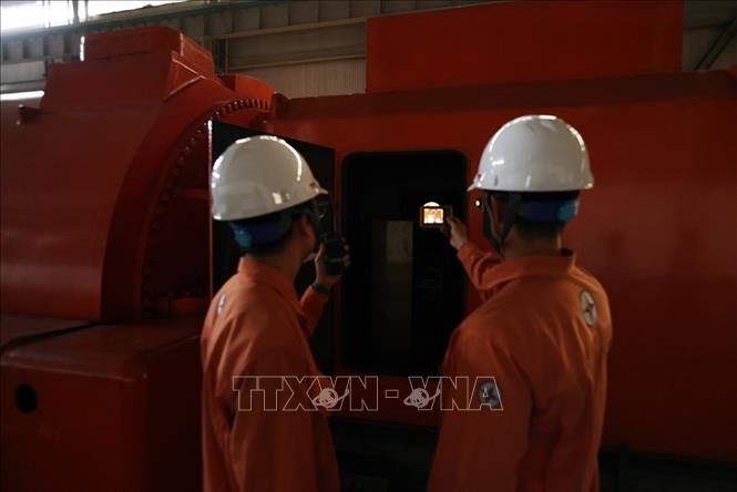 Kiểm tra nhiệt độ của máy phát điện trong ca trực ở nhà máy nhiệt điện của Công ty cổ phần nhiệt điện Quảng Ninh. Ảnh: Vũ Sinh - TTXVN