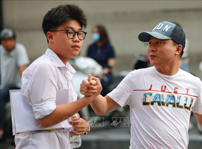 Phụ huynh dặn dò, động viên thí sinh trước khi bước vào môn thi đầu tiên tại điểm thi trường THCS Ngô Sĩ Liên (quận Hoàn Kiếm). Ảnh: Thanh Tùng - TTXVN