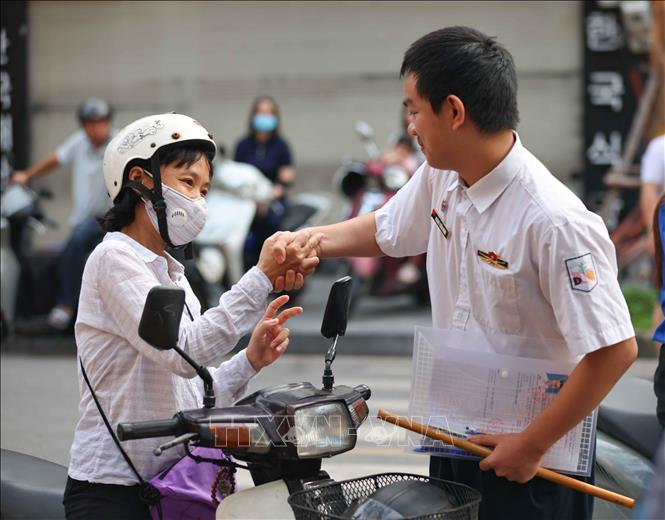 Phụ huynh dặn dò, động viên thí sinh trước khi bước vào môn thi đầu tiên tại điểm thi trường THCS Ngô Sĩ Liên (quận Hoàn Kiếm). Ảnh: Thanh Tùng - TTXVN