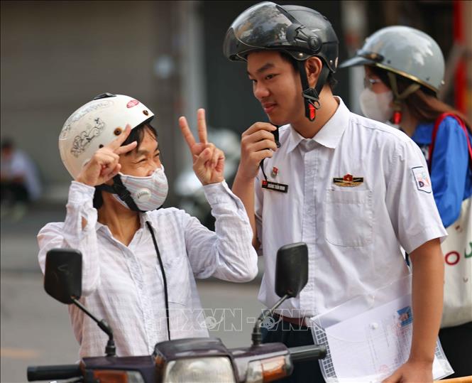 Phụ huynh dặn dò, động viên thí sinh trước khi bước vào môn thi đầu tiên tại điểm thi trường THCS Ngô Sĩ Liên (quận Hoàn Kiếm). Ảnh: Thanh Tùng - TTXVN