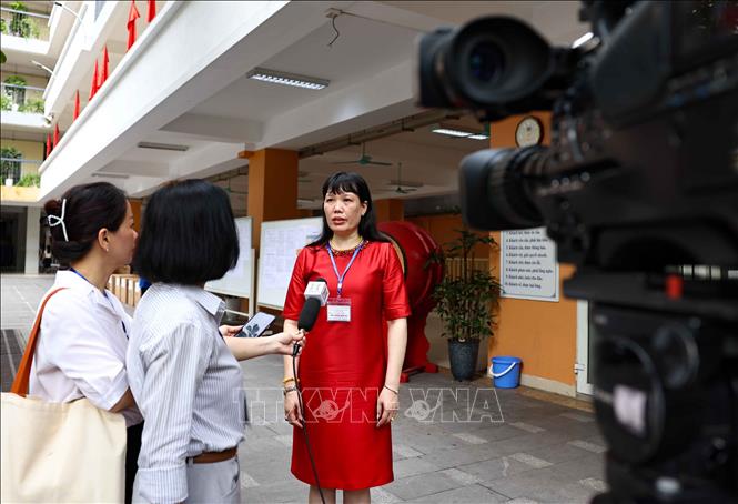 Hiệu trưởng Trường THPT Việt Đức Nguyễn Bội Quỳnh, Phó trưởng điểm thi tại THCS Ngô Sĩ Liên (quận Hoàn Kiếm) trả lời phỏng vấn các cơ quan báo chí về công tác đảm bảo cơ sở vật chật, an ninh, an toàn điểm thi. Ảnh: Thanh Tùng - TTXVN