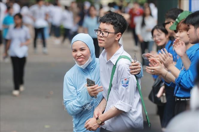 Niềm vui của phụ huynh khi thí sinh hoàn thành môn thi đầu tiên môn Ngữ văn. Ảnh: Minh Quyết - TTXVN