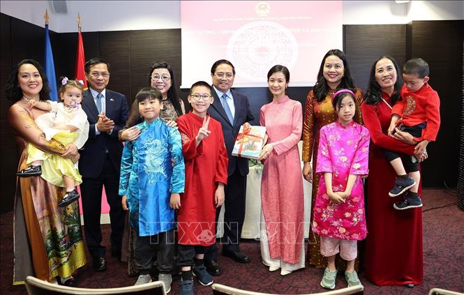 Thủ tướng Phạm Minh Chính và Phu nhân tặng sách học tiếng Việt cho cộng đồng người Việt Nam tại Estonia. Ảnh: Dương Giang-TTXVN 
