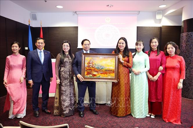 Thủ tướng Phạm Minh Chính và Phu nhân tặng bức tranh phong cảnh quê hương cho cán bộ nhân viên Đại sứ quán Việt Nam tại Estonia. Ảnh: Dương Giang-TTXVN 
