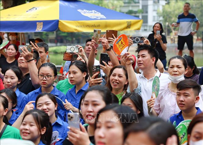 Phụ huynh chờ đón thí sinh thi môn Ngoại ngữ bên ngoài điểm thi Trường THPT Trần Nhân Tông, quận Hai Bài Trưng. Ảnh: Thanh Tùng - TTXVN