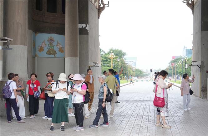 Một nhóm du khách nước ngoài thăm quan và chụp ảnh kỷ niệm tại Patouxay. Ảnh: Đỗ Bá Thành - PV TTXVN tại Lào