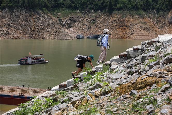 Khách du lịch mệt mỏi khi leo những bậc thang dài từ dưới bến thuyền bị cạn để quay về lại cảng Thung Nai. Ảnh: Trọng Đạt-TTXVN