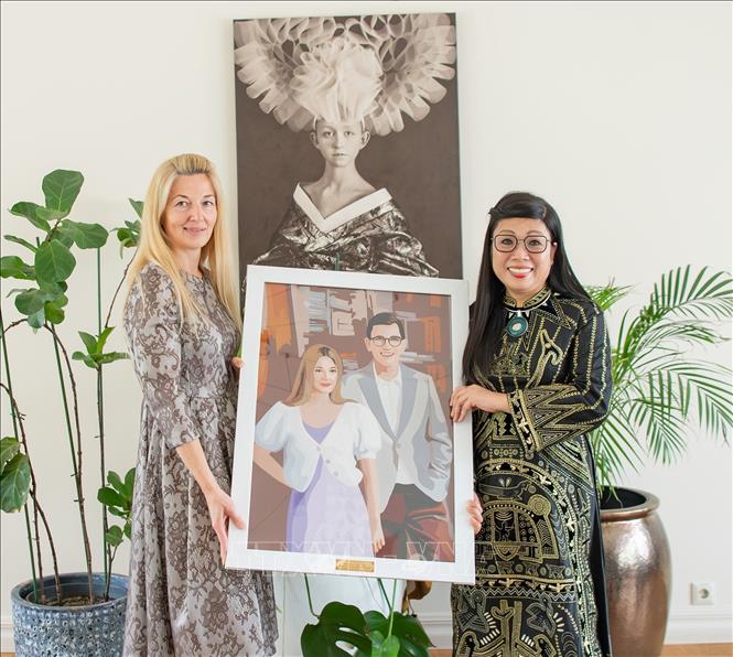 Madam Le Thi Bich Tran presents a mosaic of the Estonian Prime Minister and his wife crafted from nearly 2,000 pieces of fabric to the Estonian lady.. VNA Photo: Dương Giang