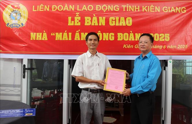 Ông Nguyễn Thành Tấn, Phó Chủ tịch Công đoàn ngành Giáo dục trao quyết định bàn giao “Mái ấm Công đoàn” cho đoàn viên. Ảnh: Lê Huy Hải - TTXVN