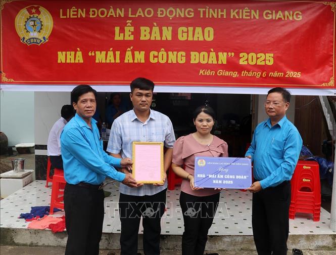 Ông Nguyễn Thành Tấn, Phó Chủ tịch Công đoàn ngành Giáo dục (phải) trao biển “Mái ấm Công đoàn” cho đoàn viên Nguyễn Thị Kim Khoa, công đoàn cơ sở Trường phổ thông Dân tộc nội trú THCS Giồng Riềng (huyện Giồng Riềng). Ảnh: Lê Huy Hải - TTXVN
