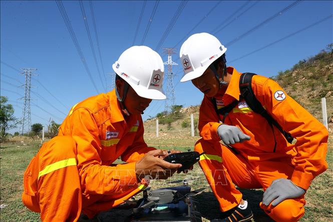 Công nhân đội truyền tải điện Bắc Bình (TTĐ Bình Thuận) sử dụng thiết bị bay không người lái kiểm tra đường dây 500kV Vĩnh Tân - Sông Mây. Ảnh: Huy Hùng - TTXVN