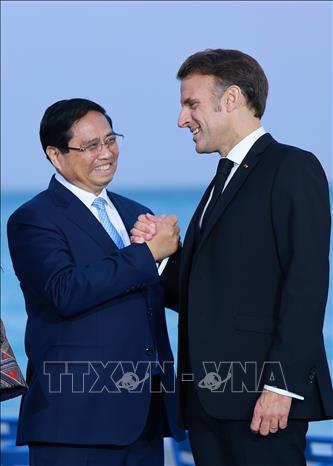 French President Emmanuel Macron welcomes Prime Minister Pham Minh Chinh. VNA Photo: Dương Giang