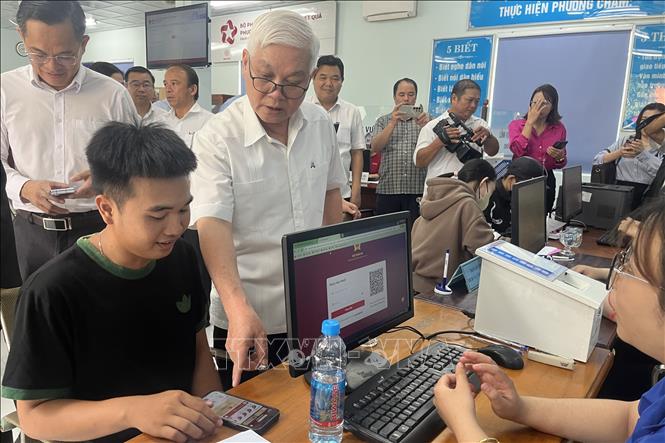 Bí thư Tỉnh ủy Nguyễn Văn Lợi kiểm tra giải quyết thủ tục hành chính tại bộ phận một cửa. Ảnh: Văn Hướng - TTXVN