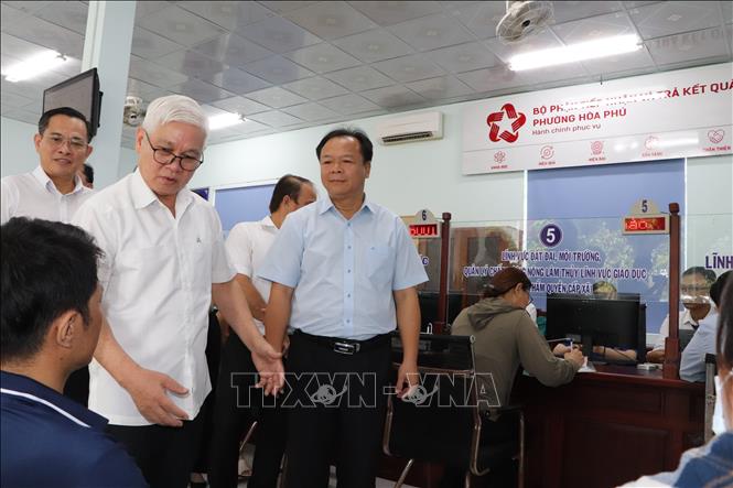 Bí thư Tỉnh ủy Nguyễn Văn Lợi kiểm tra giải quyết thủ tục hành chính tại bộ phận một cửa. Ảnh: Văn Hướng - TTXVN