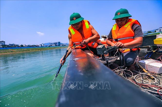 Lực lượng làm nhiệm vụ dùng trang thiết bị chuyên dụng thực hiện dò tìm trên tổng diện khoảng 29,5ha khu vực lòng sông hạ lưu thủy điện Hòa Bình. Ảnh: Trọng Đạt - TTXVN