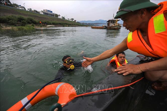 Lực lượng công binh, người nhái lặn tìm hàng giờ dưới nước khi bắt được các tín hiệu từ máy rà vật nổ kim loại. Ảnh: Trọng Đạt - TTXVN