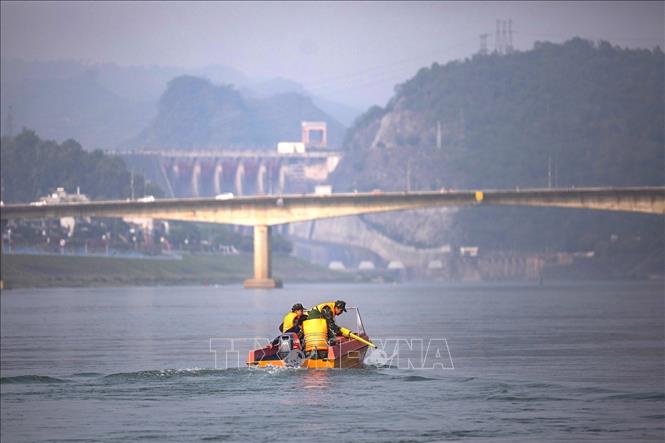 Các chiến sĩ trong đội dò tìm lên thuyền thực hiện nhiệm vụ trên dòng sông Đà phía hạ lưu thủy điện Hòa Bình. Ảnh: Trọng Đạt - TTXVN