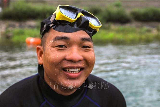 Thiếu tá Bùi Văn Đăng, Đại đội trưởng Đại đội Công binh (Bộ Chỉ huy Quân sự tỉnh Hòa Bình) trực tiếp tham gia tất cả các buổi lặn tìm kiếm vật nổ. Ảnh: Trọng Đạt - TTXVN