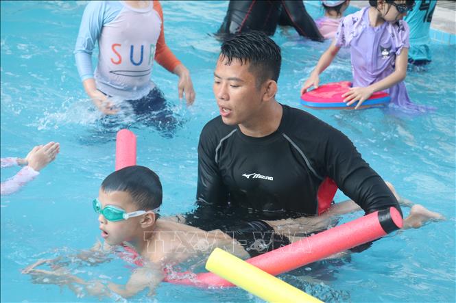 Huấn luyện viên dạy bơi cho trẻ em tại bể bơi Khách sạn Dầu khí (thành phố Thái Bình). Ảnh: Vũ Quang – TTXVN 