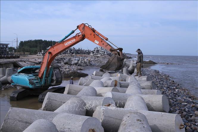 Máy móc thi công lắp đặt mỏ kè chữ T, tại hạng mục thi công kè đê biển Hải Thịnh II và III. Ảnh: Công Luật - TTXVN