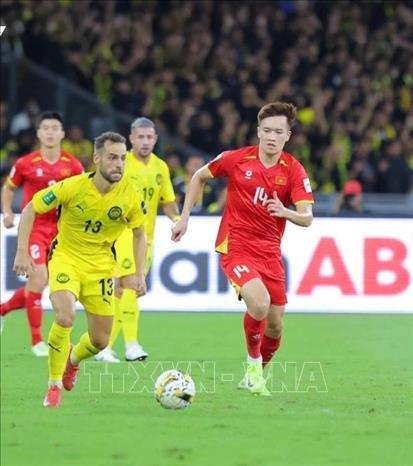Nỗ lực đi bóng của Hoàng Đức (14-tuyển Việt Nam) trước các cầu thủ Malaysia. Ảnh: TTXVN phát