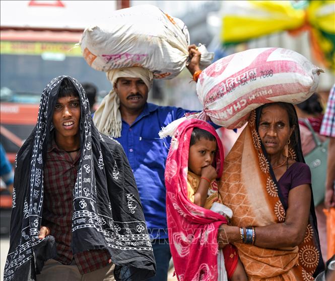 Người dân di chuyển trên đường phố dưới trời nắng nóng tại New Delhi, Ấn Độ. Ảnh: ANI/TTXVN