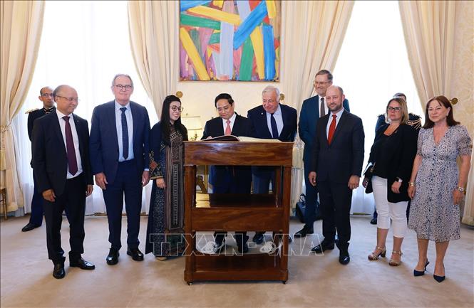 Thủ tướng Phạm Minh Chính ký sổ lưu niệm. Ảnh: Dương Giang-TTXVN