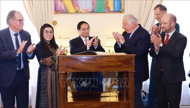 Thủ tướng Phạm Minh Chính ký sổ lưu niệm. Ảnh: Dương Giang-TTXVN