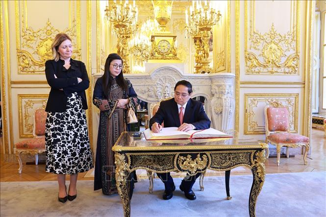 Thủ tướng Phạm Minh Chính viết sổ lưu bút. Ảnh: Dương Giang-TTXVN