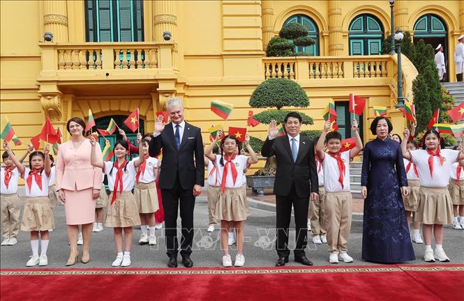Chủ tịch nước Lương Cường và Phu nhân cùng Tổng thống Cộng hoà Litva Gitanas Nauseda và Phu nhân với thiếu nhi Thủ đô tại lễ đón. Ảnh: Lâm Khánh – TTXVN