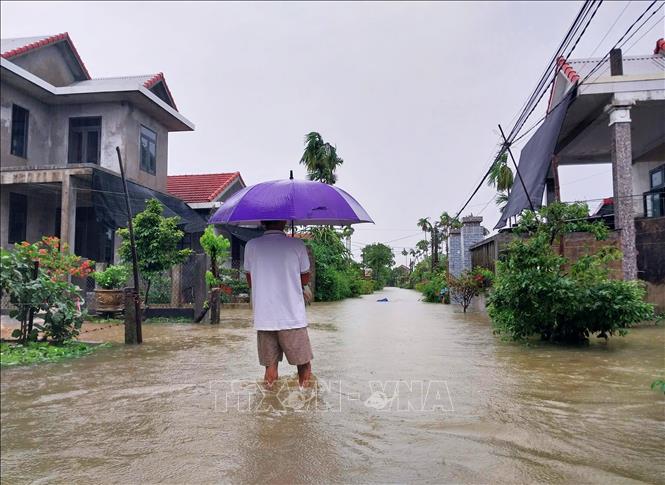 Ngập lụt gây khó khăn trong việc đi lại của người dân. Ảnh: Tường Vi - TTXVN