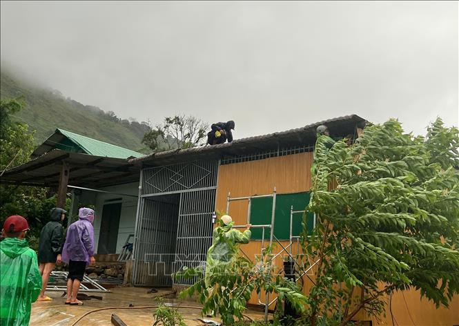 Lực lượng chức năng tỉnh Kon Tum hỗ trợ người dân khắc phục thiệt hại về nhà ở. Ảnh: TTXVN phát
