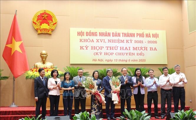 Các đại biểu tặng hoa chúc mừng tân Phó Chủ tịch HĐND thành phố và tân Phó Chủ tịch UBND thành phố Hà Nội. Ảnh: Nguyễn Thắng - TTXVN