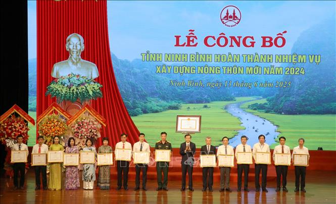 Ông Đoàn Minh Huấn, Ủy viên BCH Trung ương Đảng, Bí thư Tỉnh ủy Ninh Bình trao Bằng khen cho 34 tập thể, 49 cá nhân và 7 hộ gia đình vì đã có thành tích xuất sắc trong phong trào thi đua cả nước chung sức xây dựng nông thôn mới, giai đoạn 2021-2025 trên địa bàn tỉnh. Ảnh: Thùy Dung - TTXVN