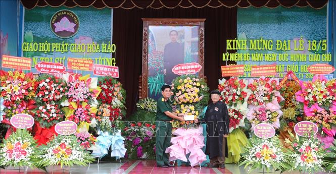 Đại diện lãnh đạo Bộ Tư lệnh Quân khu 9 (trái) chúc mừng Đại lễ kỷ niệm 86 năm Ngày khai sáng đạo Phật giáo Hòa Hảo. Đại biểu tham dự buổi lễ. Ảnh: Công Mạo-TTXVN