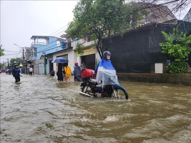 Người dân đi lại khó khăn vì ngập lụt. Ảnh: Mai Trang - TTXVN