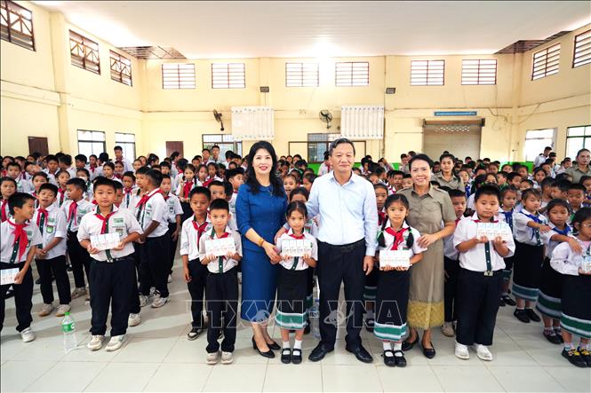 Đại sứ Nguyễn Minh Tâm và phu nhân chụp ảnh cùng với đại diện nhà trường và các học sinh Trường song ngữ Lào - Việt Nam Nguyễn Du. Ảnh: Đỗ Bá Thành - PV TTXVN tại Lào