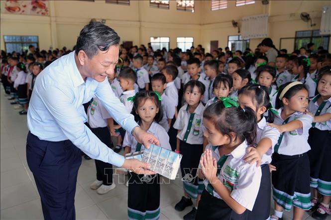 Đại sứ Nguyễn Minh Tâm tặng sữa cho các học sinh Trường song ngữ Lào - Việt Nam Nguyễn Du. Ảnh: Đỗ Bá Thành - PV TTXVN tại Lào