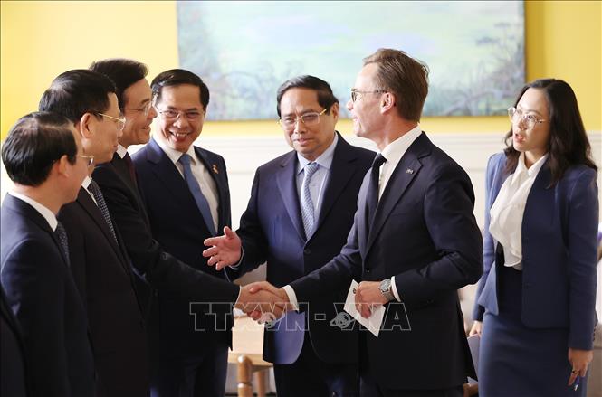 Thủ tướng Phạm Minh Chính giới thiệu với Thủ tướng Thụy Điển Ulf Kristersson thành viên đoàn Việt Nam. Ảnh: Dương Giang-TTXVN
