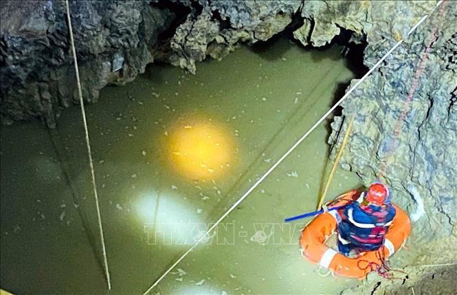 Việc bơm hút nước làm địa chất diễn biến phức tạp, xuất hiện các mạch nước ngầm chảy mạnh kèm bùn đất, có vết nứt và âm thanh đất lở, gây nguy hiểm cao cho lực lượng cứu hộ. Ảnh: TTXVN phát