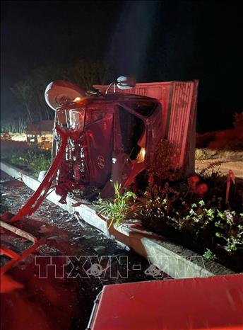 Cú va chạm mạnh khiến xe tải bị lật ngang, nằm trên dải phân cách. Ảnh: TTXVN phát