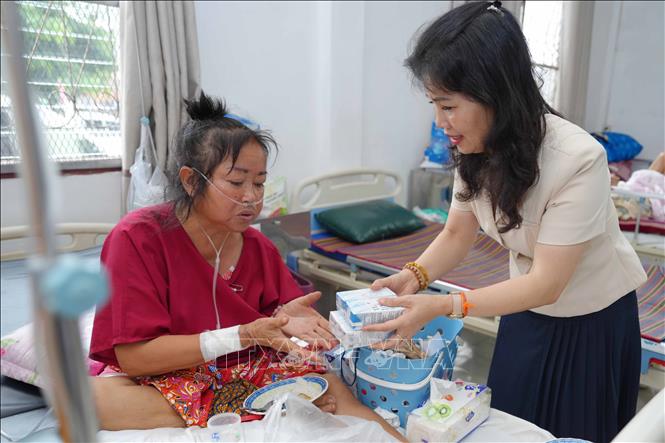 Bà Vũ Thị Dung, phu nhân Đại sứ Việt Nam tại Lào đến tận phòng bệnh ở Trung tâm Ung thư của Lào để động viên, trao quà. Ảnh: Đỗ Bá Thành - PV TTXVN tại Lào