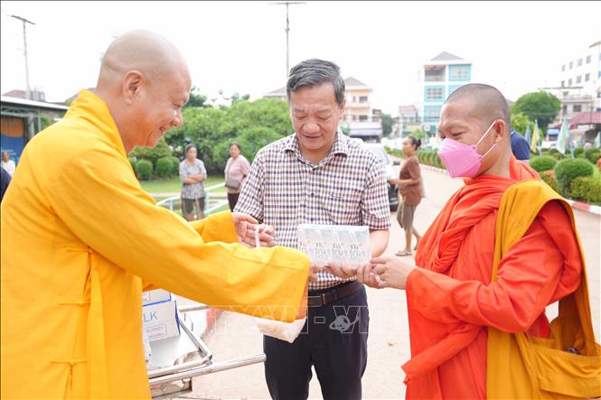 Đại sứ Nguyễn Minh Tâm và Thượng tọa Thích Minh Quang trao quà cho một nhà sư tại Lào. Ảnh: Đỗ Bá Thành - PV TTXVN tại Lào