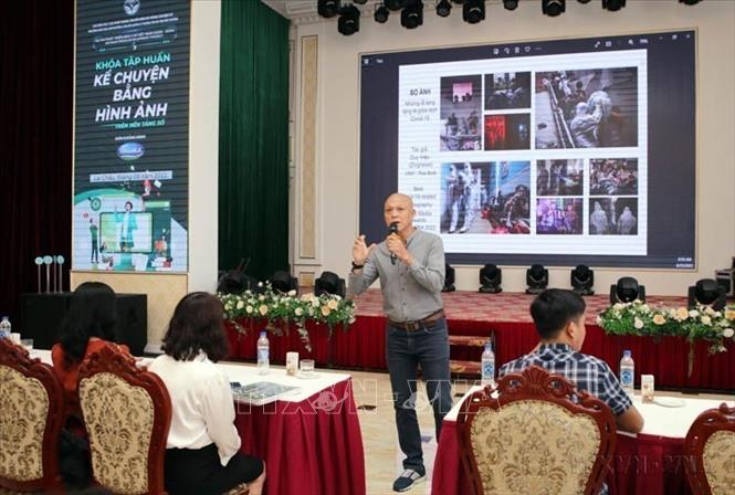 Nhiếp ảnh gia Nguyễn Á giới thiệu, kể chuyện về các tác phẩm ảnh xuất sắc cho học viên tại lớp tập huấn “Kể chuyện bằng hình ảnh trên các loại hình truyền thông” (Lai Châu, 25/8/2022). Ảnh: Quý Trung – TTXVN