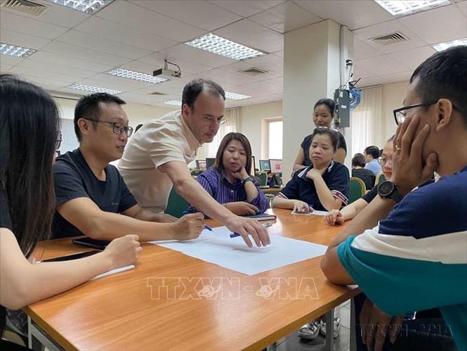 Nhà báo Alain Gérard, Tổng biên tập báo điện tử Latitudes, giảng viên Đại học Tự do Bruxelles (ULB) trao đổi với các học viên về phương thức tổ chức một bài báo hiện đại trên trang thông tin điện tử cho phóng viên, biên tập viên của TTXVN. Ảnh: TTXVN