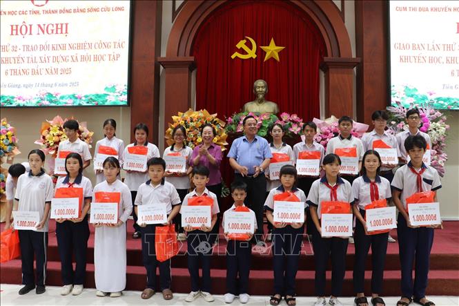 Trao học bổng cho học sinh nghèo, hiếu học. Ảnh: Minh Trí - TTXVN