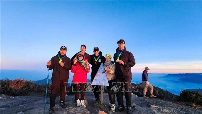Tourists take part in trekking tour to Lung Cu peak in Nam Co commune. VNA/Photo by courtesy